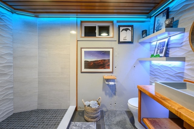 bathroom featuring a tile shower and toilet