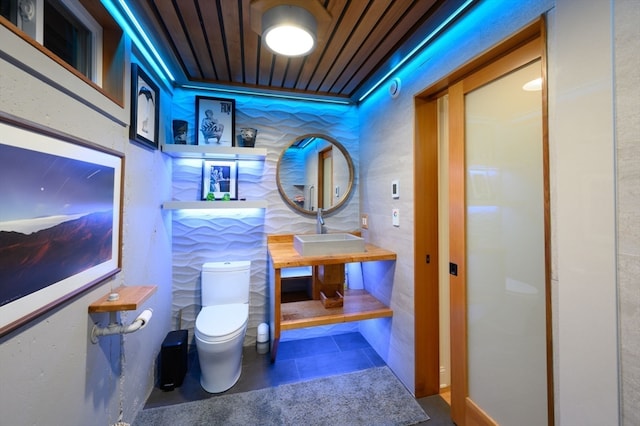 interior space with dark tile patterned flooring, sink, and wooden ceiling