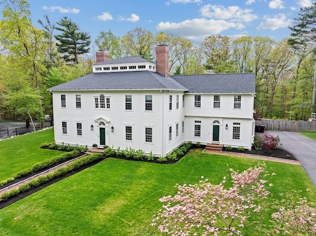 view of front of home featuring entry steps, a chimney, and a shingled roof