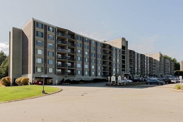 view of apartment building / complex featuring uncovered parking