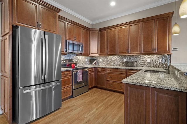 kitchen with crown molding, pendant lighting, stainless steel appliances, and sink