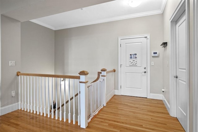 corridor with light wood-type flooring and ornamental molding