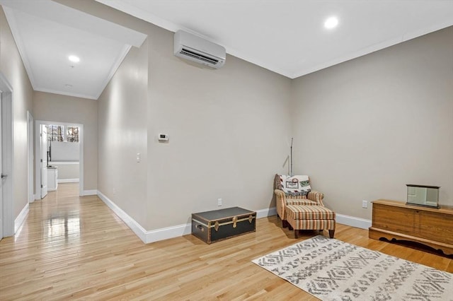 sitting room featuring light wood-type flooring, a wall mounted AC, and crown molding