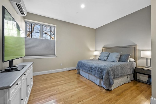 bedroom featuring an AC wall unit and light wood-type flooring