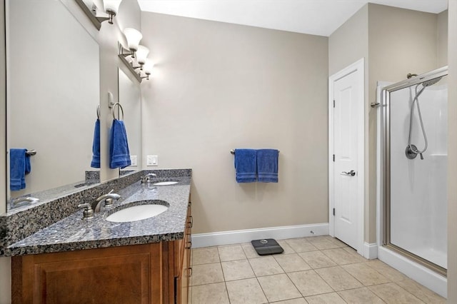 bathroom with a shower with door, vanity, and tile patterned flooring