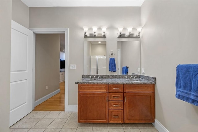 bathroom with tile patterned flooring, vanity, and walk in shower