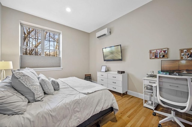 bedroom with a wall mounted air conditioner and light wood-type flooring