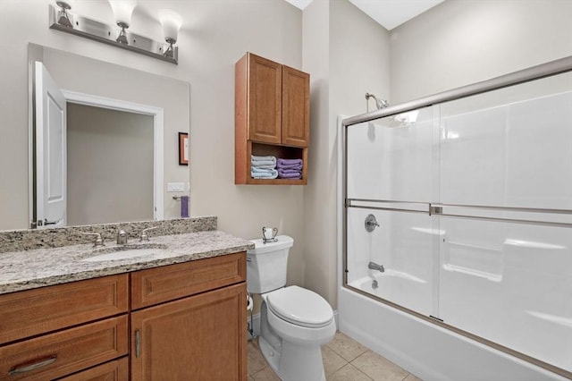 full bathroom with tile patterned floors, vanity, bath / shower combo with glass door, and toilet