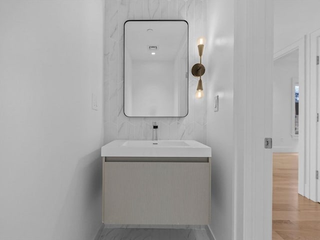 bathroom featuring baseboards, wood finished floors, and vanity