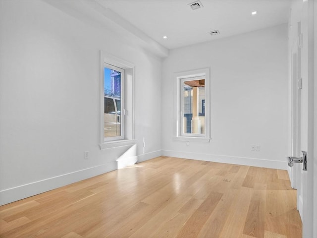 spare room featuring light wood-style floors, baseboards, visible vents, and recessed lighting