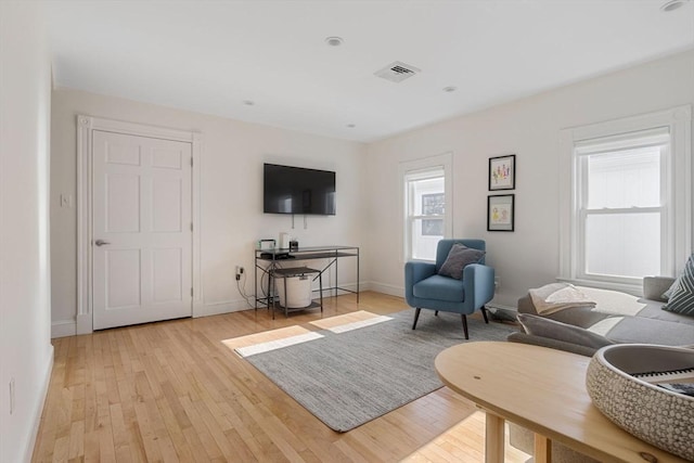 living area featuring visible vents, baseboards, and light wood-style flooring