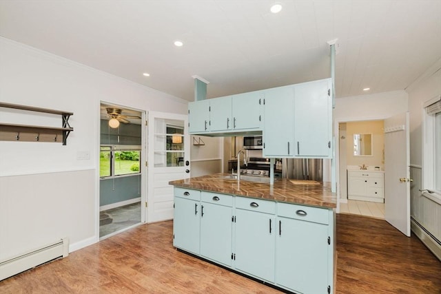 9 Mount Hope St, North Attleboro, MA 02760 - kitchen with baseboard heating, blue cabinetry, wood finished floors, ornamental molding, and a sink