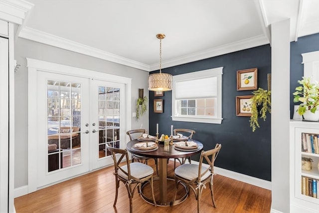 dining room with ornamental molding, hardwood / wood-style floors, and french doors