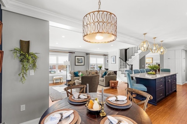 dining room featuring crown molding and light hardwood / wood-style floors