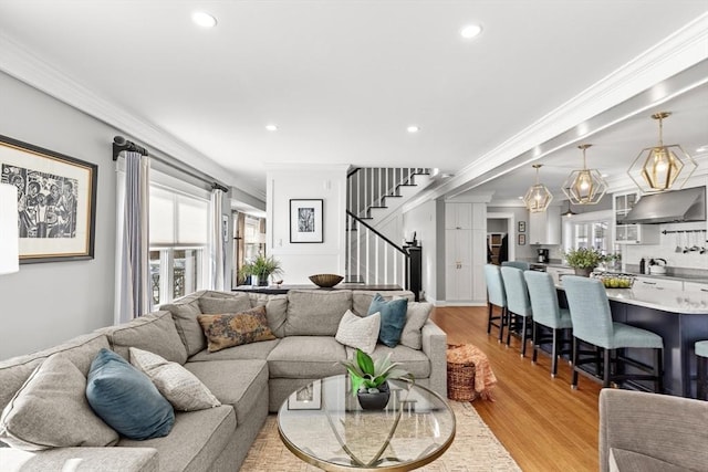 living room with crown molding and light hardwood / wood-style flooring