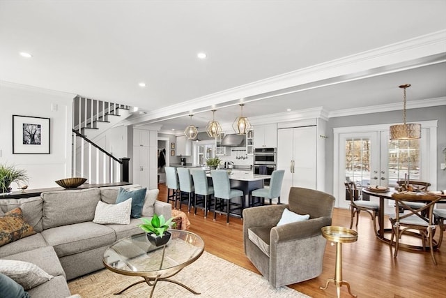 living room with french doors, crown molding, and light hardwood / wood-style flooring