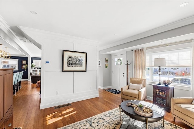 living room with ornamental molding and wood-type flooring