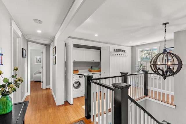 hall with washer / dryer and light hardwood / wood-style floors