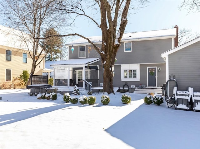 view of snow covered rear of property