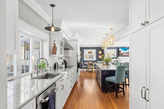 kitchen featuring sink, hanging light fixtures, and white cabinets