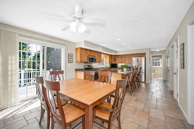 dining space featuring healthy amount of natural light, stone tile floors, baseboards, and recessed lighting
