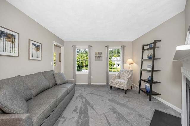 carpeted living room with baseboards and a fireplace