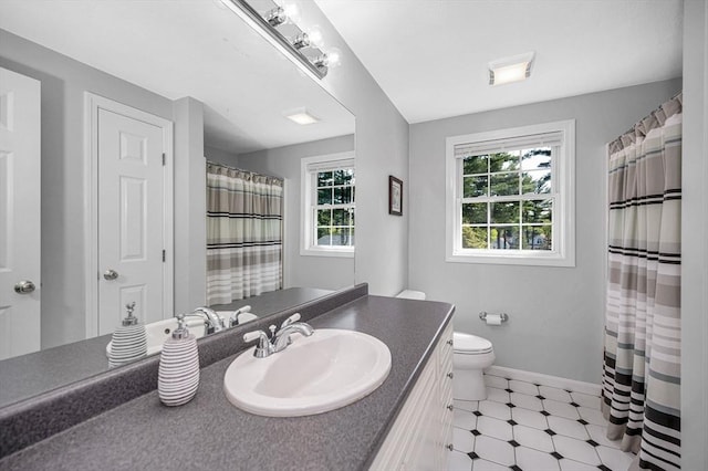 bathroom with toilet, vanity, baseboards, a shower with shower curtain, and tile patterned floors