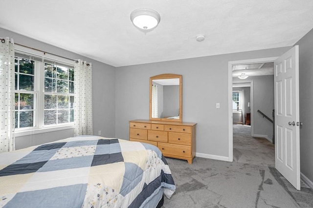 bedroom featuring carpet, multiple windows, and baseboards