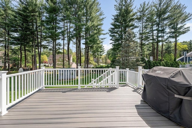 wooden deck featuring view of scattered trees and area for grilling
