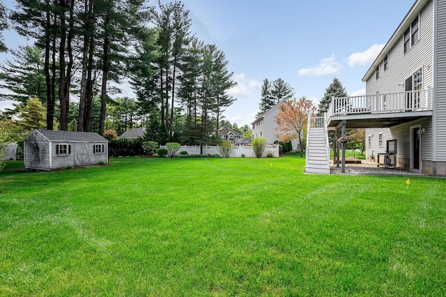 view of yard featuring a deck, stairs, an outdoor structure, and a shed