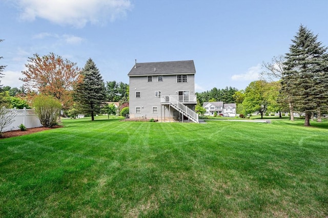 rear view of property featuring stairs and a wooden deck