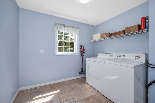 laundry room with baseboards, washer and clothes dryer, and light stone finish flooring