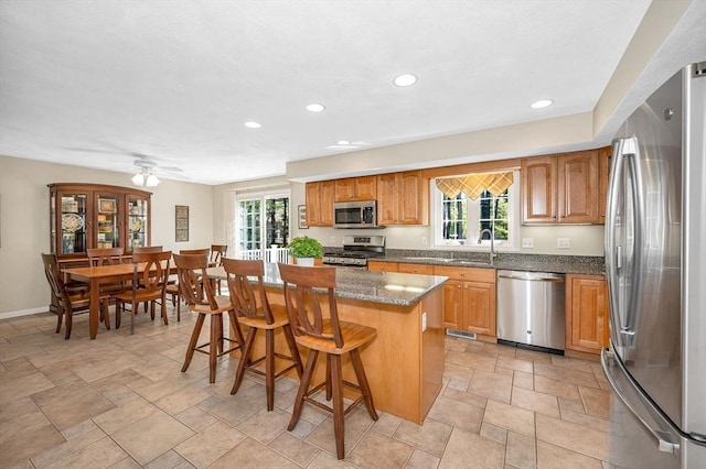 kitchen with stainless steel appliances, recessed lighting, plenty of natural light, a kitchen island, and a breakfast bar