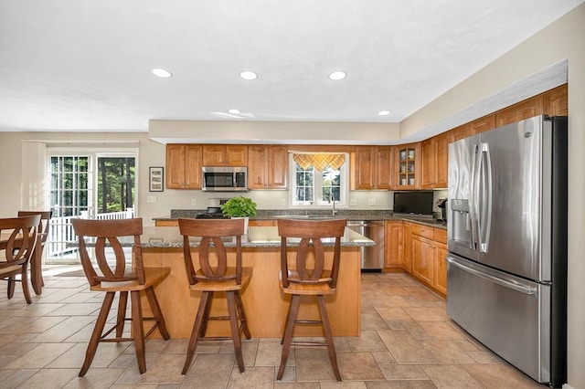 kitchen featuring appliances with stainless steel finishes, plenty of natural light, a center island, a breakfast bar, and recessed lighting