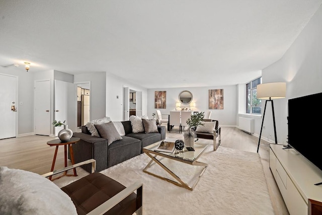 living room featuring light hardwood / wood-style flooring and radiator