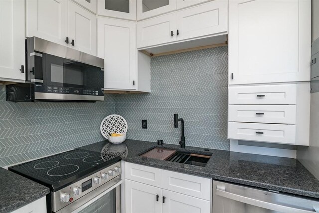 140 Chestnut St Unit 606, Springfield, MA 01103 - kitchen featuring stainless steel appliances, a sink, tasteful backsplash, white cabinetry, and glass insert cabinets