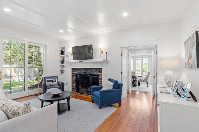 196 Elm St, Concord, MA 01742 - living area with plenty of natural light, light wood-style floors, a brick fireplace, beamed ceiling, and recessed lighting
