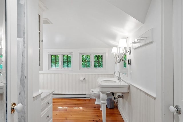 196 Elm St, Concord, MA 01742 - bathroom with a baseboard radiator, a wainscoted wall, vaulted ceiling, and hardwood / wood-style flooring