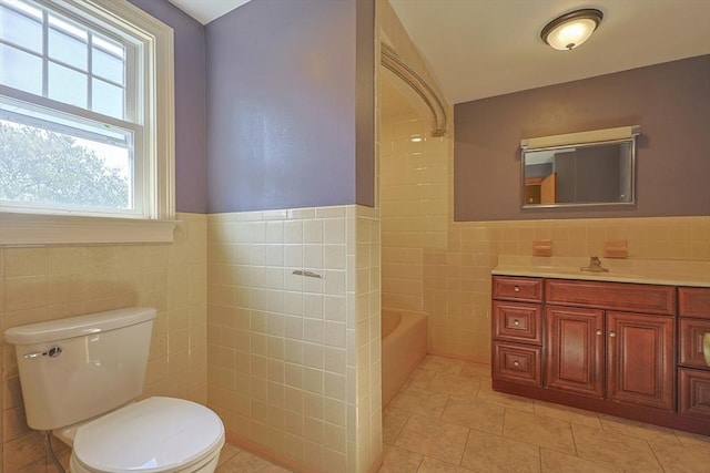 full bathroom featuring tile walls, toilet, a tub, vanity, and tile patterned floors