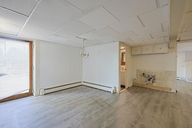 basement featuring a chandelier, wood finished floors, and wooden walls