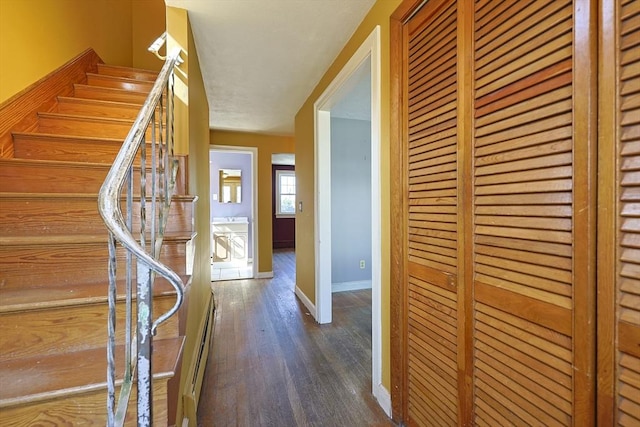hall with wood finished floors, baseboards, and stairway