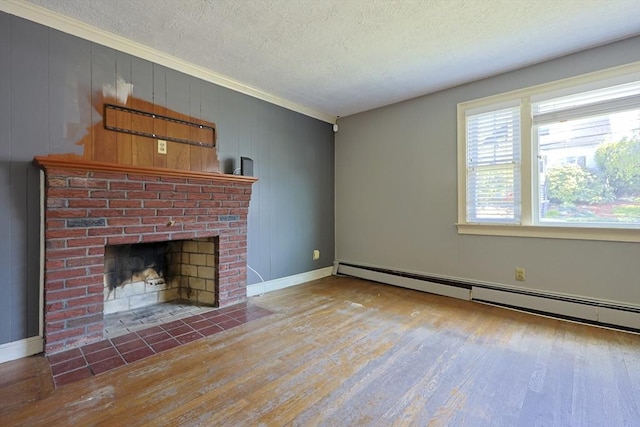 unfurnished living room with wood finished floors, a baseboard heating unit, a textured ceiling, ornamental molding, and a fireplace