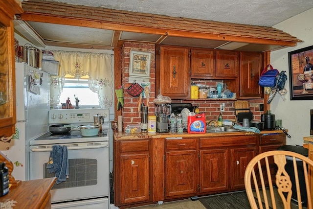 kitchen with a textured ceiling, white appliances, sink, and tasteful backsplash