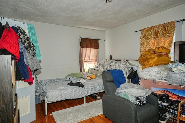 bedroom featuring wood-type flooring and a textured ceiling