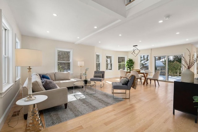 living area featuring visible vents, baseboards, light wood-style flooring, and recessed lighting