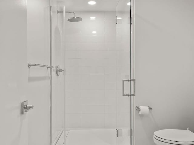 full bathroom featuring toilet and a stall shower
