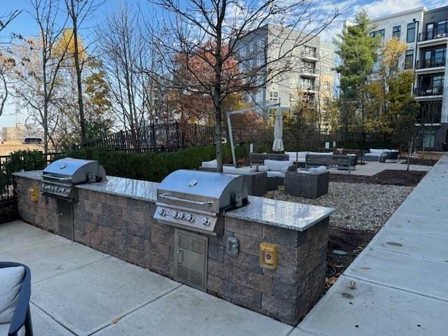 view of patio with outdoor lounge area, fence, grilling area, and area for grilling