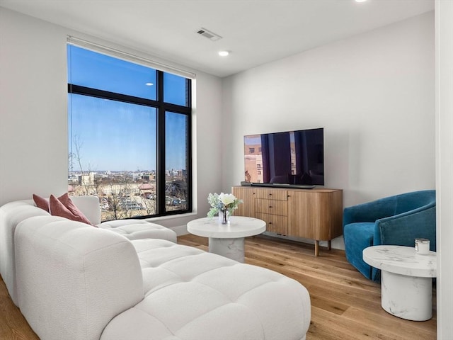 living room with visible vents, recessed lighting, and light wood-type flooring