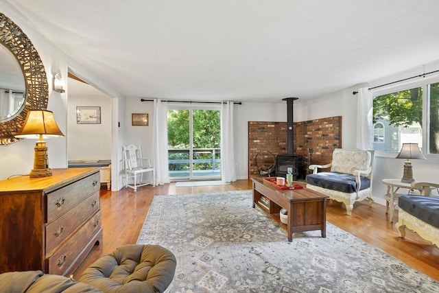 living area featuring wood finished floors, a wood stove, and baseboards