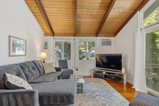 living area featuring wood finished floors, plenty of natural light, lofted ceiling with beams, and a wall mounted AC